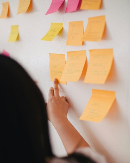 Person pointing at post it notes on the wall
